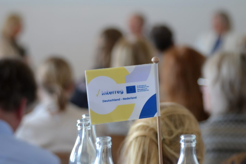 Interreg-Fahne mit 'Deutschland - Nederland' vor Publikum