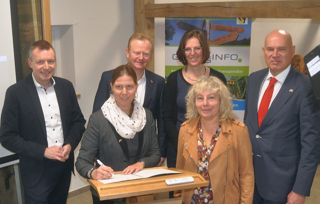 Gruppenfoto 6 Menschen. Unter anderem Niedersachsens Europaministerin Wiebke Osigus, die ein Papier (Vereinbarung zur Verlängerung der Förderung) unterzeichnet.