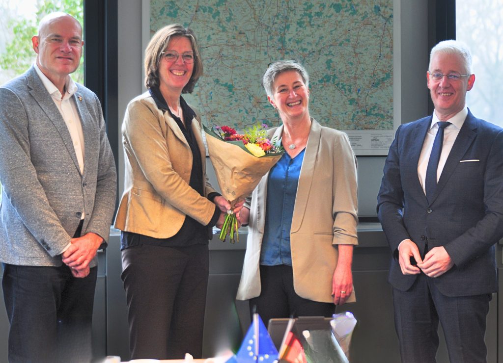 EDR-Geschäftsführer, Vorsitzende und Co-Vorsitzender der EDR überreichen Stephanie Koch einen Blumenstrauß