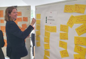 Pinnwand mit gelben Post-its und einer Frau