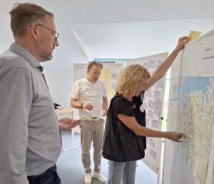 Menschen vor Landkarte und Pinnwand
