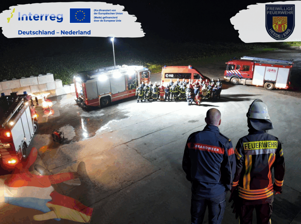 Gruppenfoto Feuerwehrleute aus Vogelperspektive. Im Vordergrund zwei Menschen mit je einer deutschen und einer niederländischen Feuerwehrkleidung. Interreg-Logo, Logo der Freiwilligen Feuerwehr Heede.