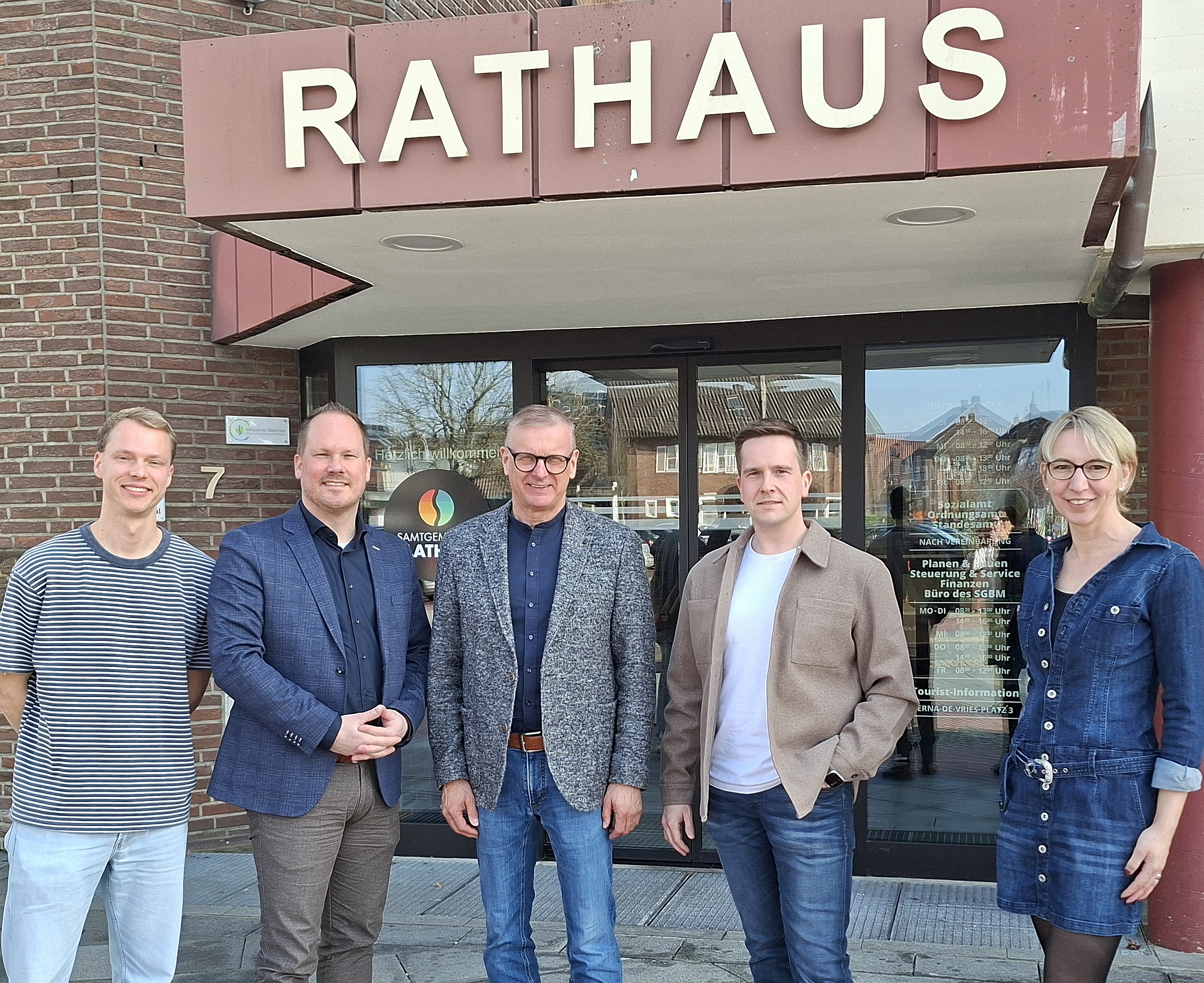Fünf Personen vor einem Rathaus / vijf personen voor een gemeentehuis