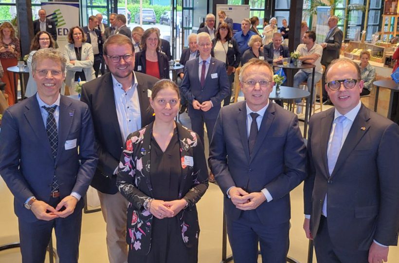 Im Hintergrund Publikum. Im Vordergrund fünf Menschen.