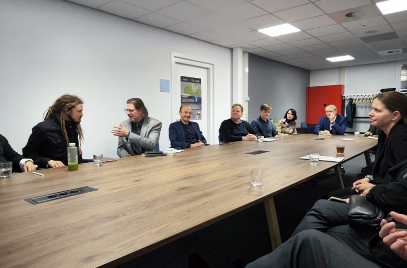 Gruppe von Menschen, die am Tisch sitzen und sich unterhalten.