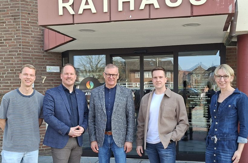 Fünf Personen vor einem Rathaus / vijf personen voor een gemeentehuis