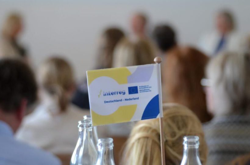 Interreg-Fahne mit 'Deutschland - Nederland' vor Publikum