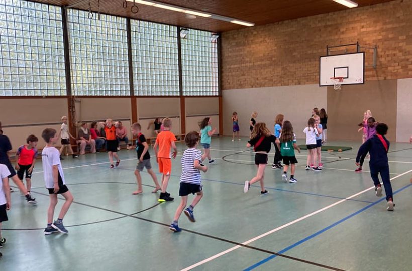 Kinder spielen in einer Turnhalle