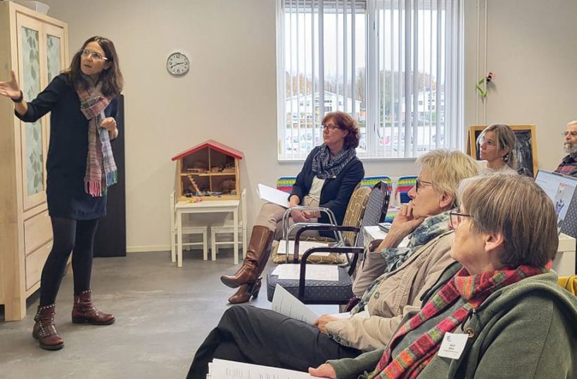 Theresa Sperling steht vor Publikum, das ihr auf Stühlen sitzend zuhört
