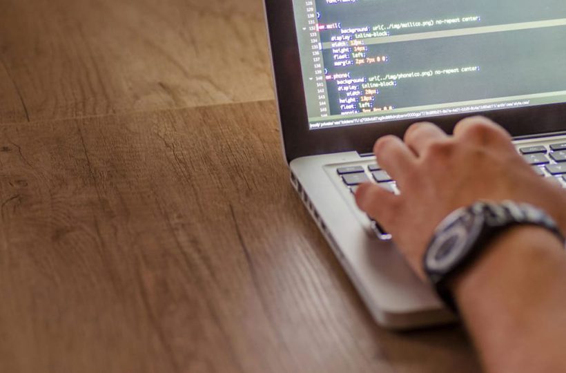 Bildausschnitt von einem Schreibtisch, auf dem ein Laptop steht