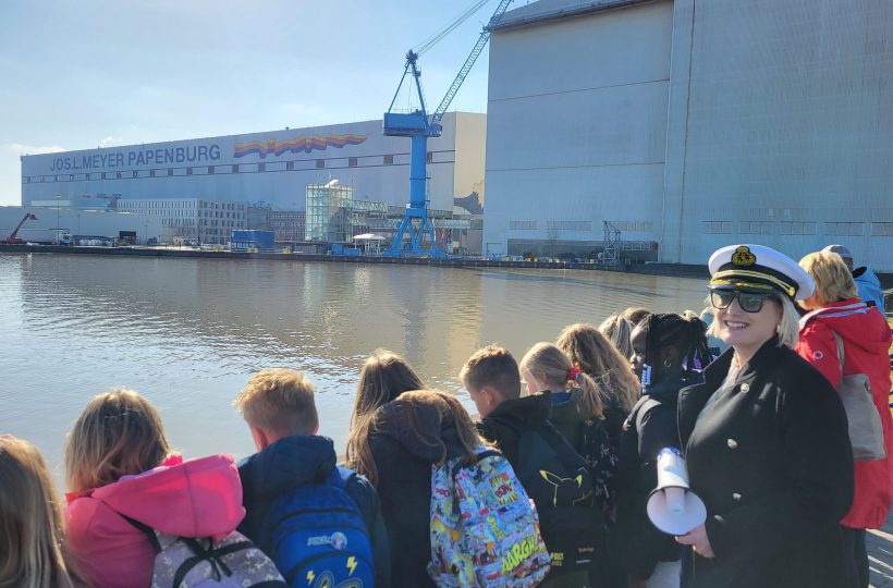 Kinder am Wasser vor Meyer Werft, Marineperson mit Megafon